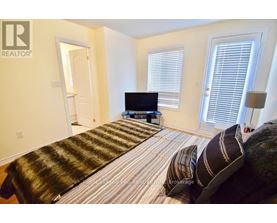 A bedroom with a bed, a television, and a window with blinds.