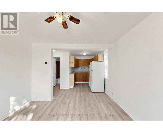 A spacious kitchen with white appliances and wooden floors.