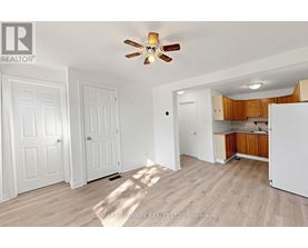 A room with a ceiling fan and wooden flooring.
