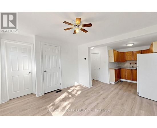 A room with a ceiling fan and wooden flooring.