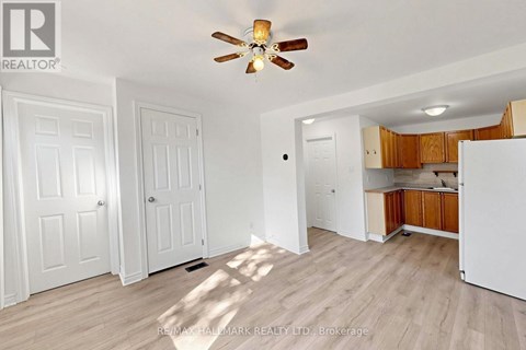 A room with a ceiling fan and wooden flooring.