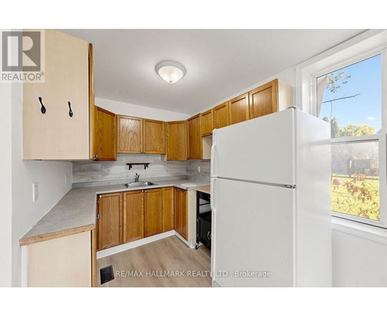 A kitchen with wooden cabinets and a white refrigerator.