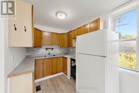 A kitchen with wooden cabinets and a white refrigerator.
