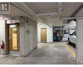 A parking garage with a car parked on the right side.