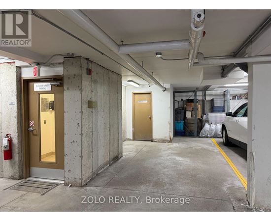 A parking garage with a car parked on the right side.