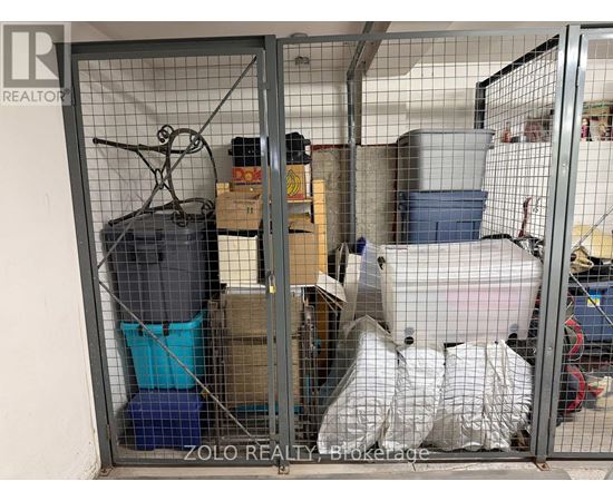 A storage unit is full of various items including a blue container, a white bag, and a black suitcase.