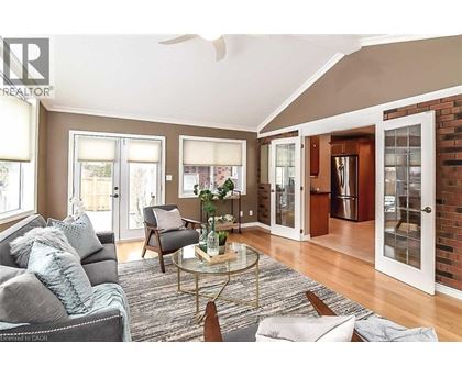 A living room with a grey couch and a glass coffee table.