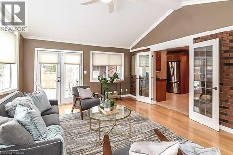 A living room with a grey couch and a glass coffee table.