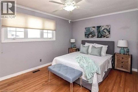 A bedroom with a bed, nightstands, and a ceiling fan.