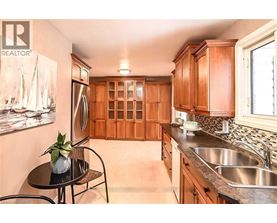 A kitchen with wooden cabinets and a black table.