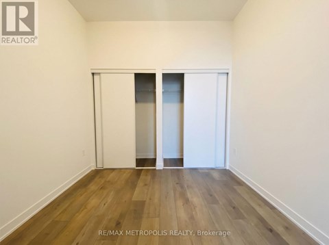 A room with a sliding door and wooden flooring.