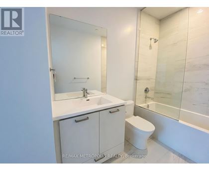 A white bathroom with a sink, toilet and bathtub.