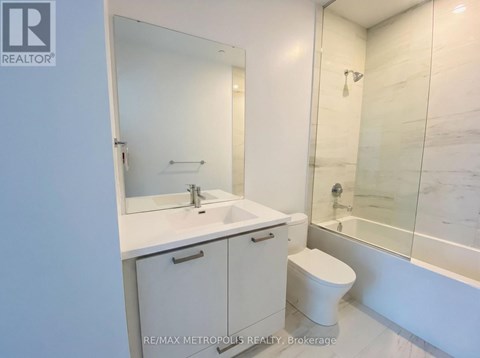 A white bathroom with a sink, toilet and bathtub.