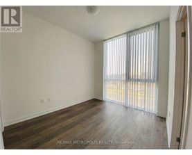 A room with wooden flooring and a window with blinds.