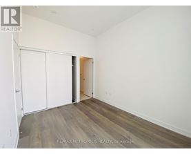 A room with a white wall and a wooden floor.