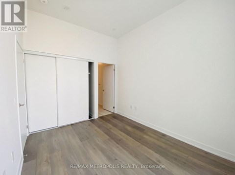 A room with a white wall and a wooden floor.