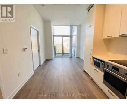 A kitchen with white cabinets and a wooden floor.