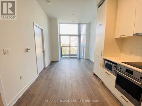 A kitchen with white cabinets and a wooden floor.