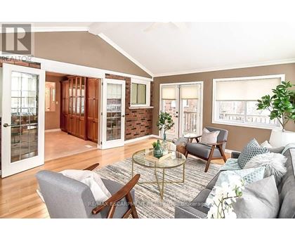 A living room with a grey couch and a glass table.