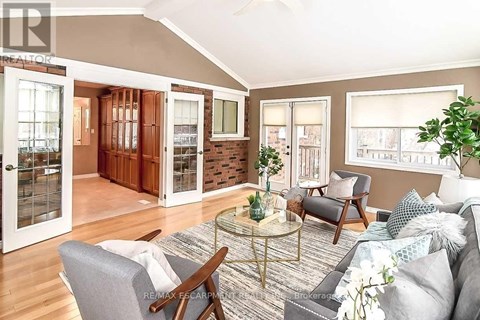 A living room with a grey couch and a glass table.