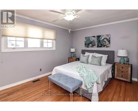 A bedroom with a bed, nightstands, and a ceiling fan.