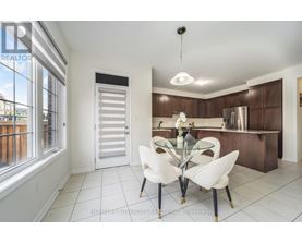 A modern kitchen with white chairs and a glass table.
