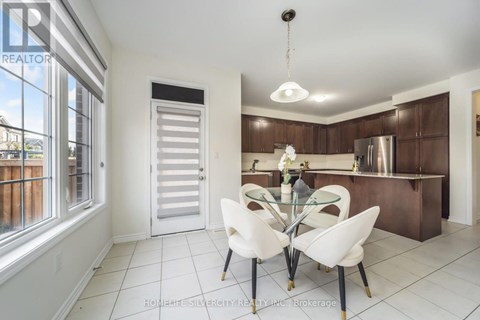 A modern kitchen with white chairs and a glass table.