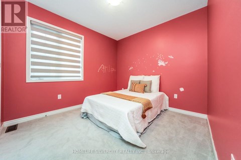 A bedroom with a bed and a window with blinds.