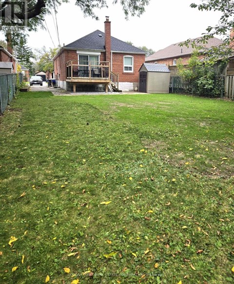 A backyard with a lawn and a house in the background.