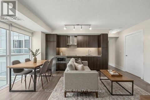 A modern living room with a dining table and chairs.