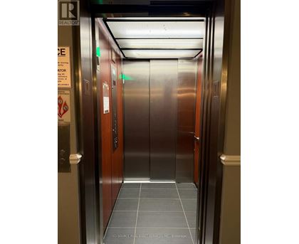 A stainless steel elevator with a sign on the left side.