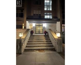 A set of stairs leading to a building entrance with lights on either side.