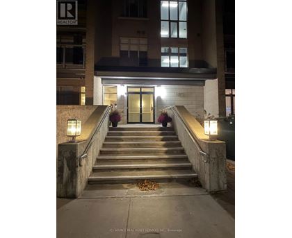 A set of stairs leading to a building entrance with lights on either side.