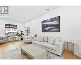 A living room with a grey couch, a coffee table, and a painting on the wall.