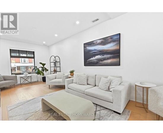 A living room with a grey couch, a coffee table, and a painting on the wall.