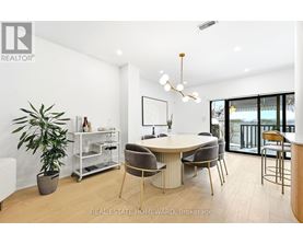 A modern dining room with a round table and chairs.