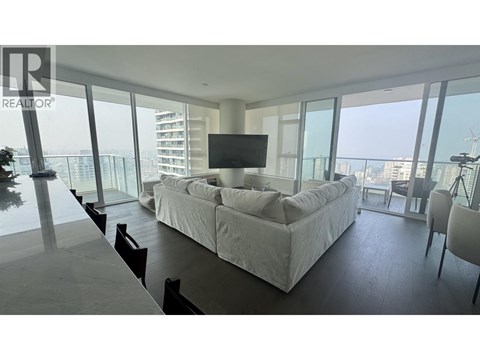 A living room with a large couch and a flat screen TV.