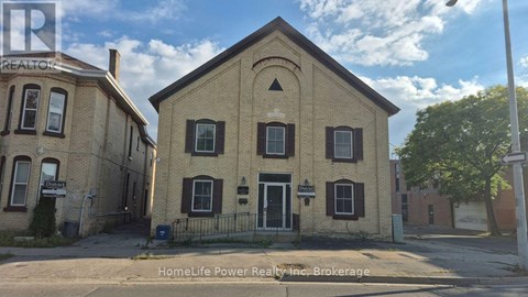 A building with a sign that says "HomeLife Power Realty Inc. Brokerage" in front of it.