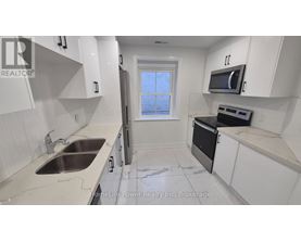 A kitchen with white cabinets and a black oven.
