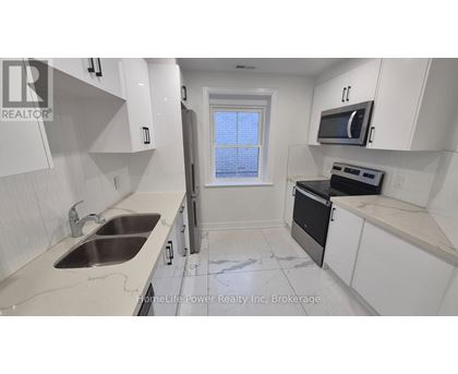 A kitchen with white cabinets and a black oven.