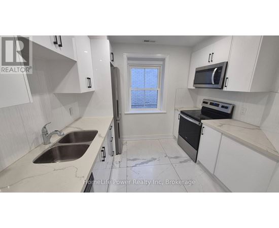 A kitchen with white cabinets and a black oven.