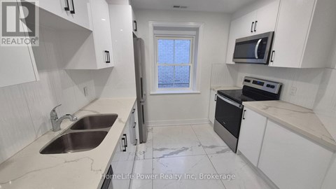 A kitchen with white cabinets and a black oven.