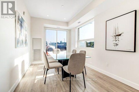 A dining room with a table and chairs.