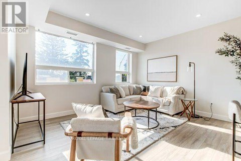 A living room with a white sofa set and a wooden coffee table.