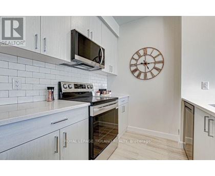 A kitchen with white cabinets and a clock on the wall.