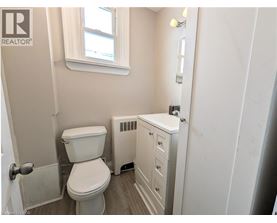 A white toilet and sink in a small bathroom.
