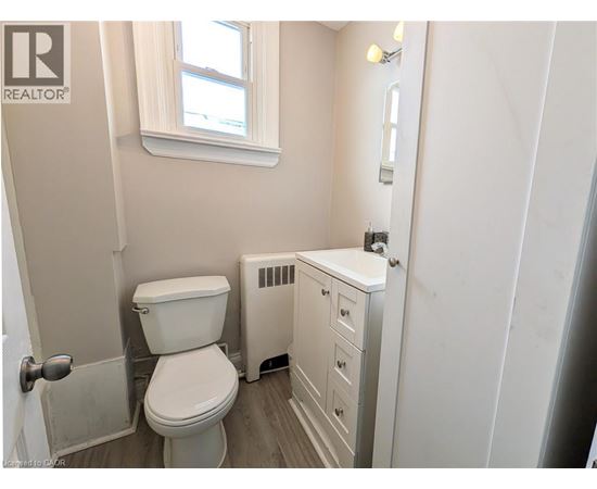 A white toilet and sink in a small bathroom.