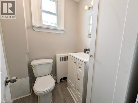 A white toilet and sink in a small bathroom.