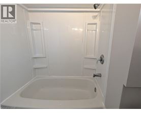 A white bathroom with a tub and shower.