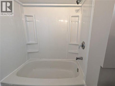 A white bathroom with a tub and shower.